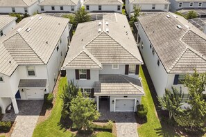 A residential area with multiple houses featuring pitched roofs and a central driveway.