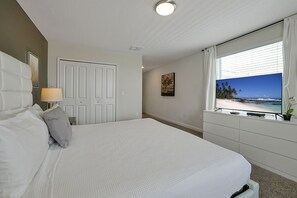 Um quarto com uma cama, cômoda, janela com vista e porta.