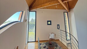 A staircase with a geometric patterned rug, wooden beams, and a view of the outside. - Gîte la Majorelle T3 de 92 m² + Terrasses, Jardin (Saint-Guiraud)
