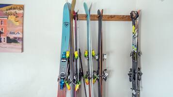 A wall-mounted ski rack with multiple pairs of skis and ski poles.