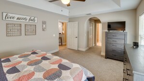 A bedroom with a bed, a ceiling fan, a dresser, a TV, and a door leading to another room. - Ocala Retreat: 4 Mi to World Equestrian Center! (Ocala)