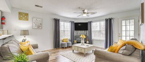 A living room with a sofa, coffee table, and a ceiling fan.