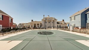 A courtyard with a green tennis court, surrounded by residential buildings. - Game Room, Hot Tub & Grill: Afton Retreat! (Afton)