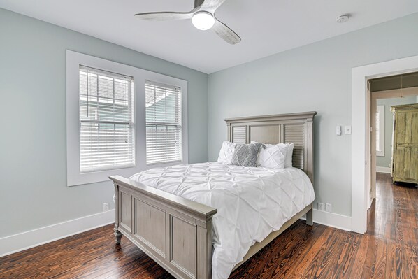 A bedroom with a bed, a ceiling fan, and hardwood flooring. - 4 Mi to Moody Gardens: Sleek Home w/ Deck & Yard! (Galveston)