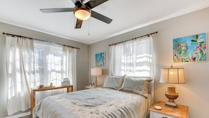 A bedroom with a bed, a nightstand, a ceiling fan, and two paintings on the wall. - Bring Your Pets! Family Haven w/ Yard in Mableton (Mableton)