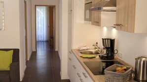 Une cuisine moderne équipée d’un évier, d’une machine à café et d’un panier de pain.