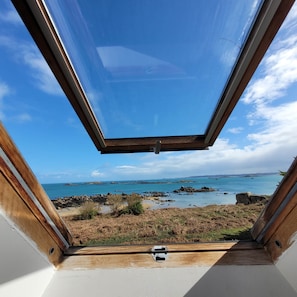 Ein Zimmer mit einem Oberlicht mit Blick auf eine zerklüftete Küstenlinie.