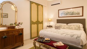 A hotel room with a bed, dresser, mirror, lamp, and a framed picture on the wall. - Via Giulia Charming Atelier apartment (Roma)