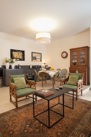 Una sala de estar con comedor, una cocina al fondo y un mueble de madera grande.