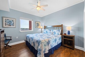 A bedroom with a bed, a nightstand, a dresser, and a ceiling fan. - Sanibel 606 (Gulf Shores)