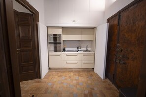 A compact kitchen with a built-in oven, a sink, and a coffee maker. - Via Giulia Charming Apartment with Balcony (Roma)