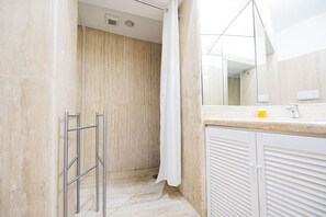 A modern bathroom with a shower, a glass door, and a white vanity with a mirror. - Via Giulia Charming Apartment with Balcony (Roma)