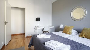 Ein Hotelzimmer mit Bett, Schreibtisch, Stuhl und Spiegel an der Wand.