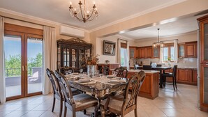 A spacious dining area with a large table, elegant chairs, and a chandelier. - Villa Aris: A Serene Experience, 3BRs, Pool & Bbq (Rethymno)