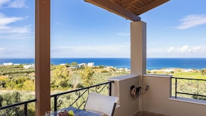 A balcony with a table, a chair, and a bowl of fruit. - Villa Aris: A Serene Experience, 3BRs, Pool & Bbq (Rethymno)