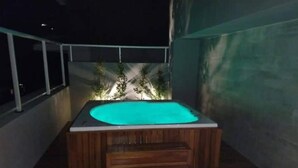 Een hottub in een overdekte buitenruimte, met een trap erheen.