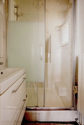 A bathroom with a glass-enclosed shower, a white vanity, and a towel rack. - Splendid apartment with Eiffel Tower view / best for Olympic Games in Paris  (Paris)