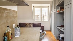 A compact kitchen with a dining table, a sofa, and a window with a city view. - Splendid apartment with Eiffel Tower view / best for Olympic Games in Paris (Paris)