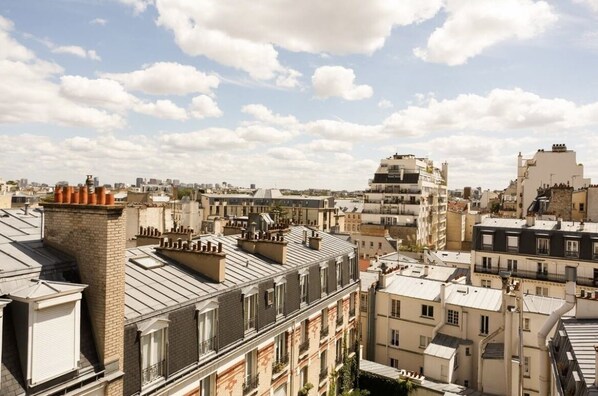 A cityscape with multiple buildings, including a prominent multi-story structure with a unique roof design. - Splendid apartment with Eiffel Tower view / best for Olympic Games in Paris  (Paris)