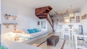 Une chambre confortable avec un lit, un bureau et un escalier menant à un étage supérieur.