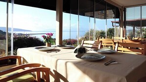 A dining area with tables set for two, overlooking a scenic view. - DÖRTMEVSİM PANSİYON (Bodrum)