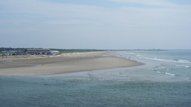 Une plage avec un bâtiment sur la gauche.