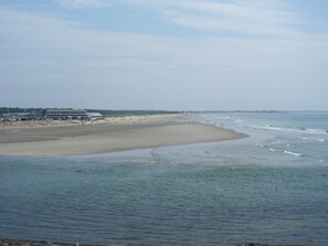 Ein Strand mit einem Gebäude auf der linken Seite.