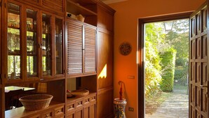 A wooden interior with cabinets, a wicker basket, and a tiled floor.