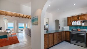 A modern kitchen with wooden cabinets, a stainless steel stove, and a teal backsplash.
