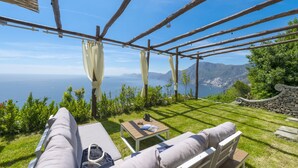 A patio with a view of the sea, a wooden pergola, and a stone wall. - Punta di Diamante - 200 Steps to Heaven (Praiano)