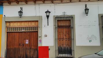 A traditional building with a wooden facade, a large wooden door, and a barred window.