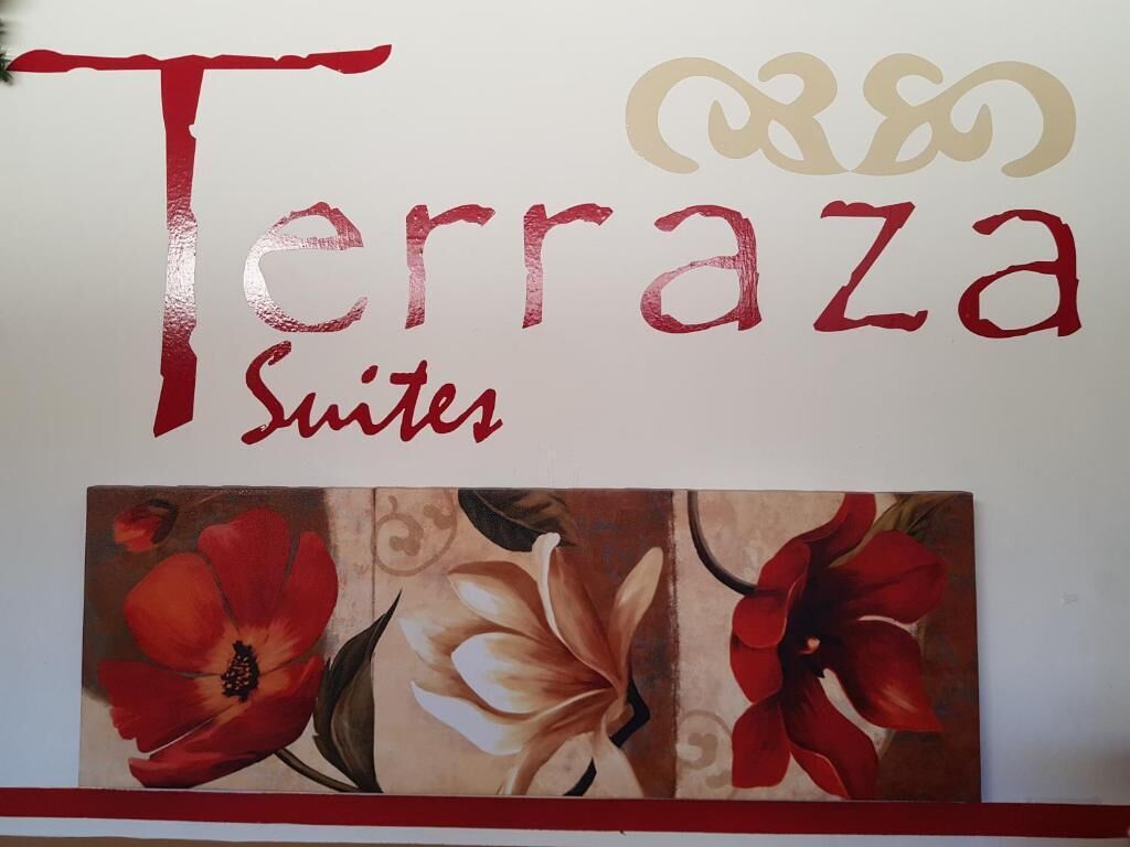 A sign for 'Terraza Suites' with floral artwork below it.