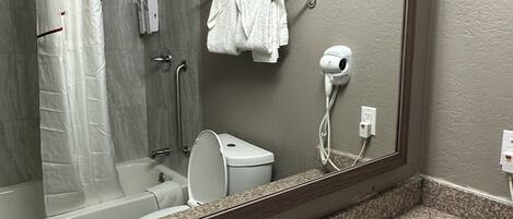 A bathroom with a shower, toilet, and sink.