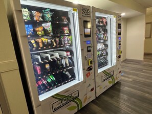 Una hilera de máquinas expendedoras con diversos aperitivos y bebidas.