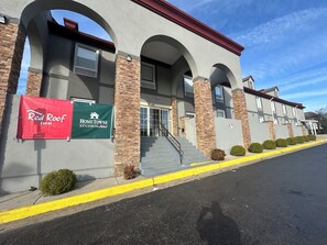 A building with a red and green banner advertising Red Roof Inn and HomeTowne Studios. - Red Roof Inn Richmond, VA – W Broad St (Richmond)
