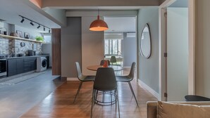 A modern kitchen with a dining area, wooden flooring, and a pendant light. - Complete 2 bedroom apartment (São Paulo)