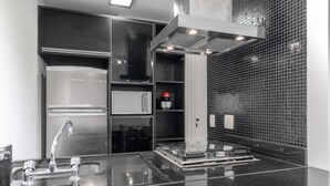 A modern kitchen with stainless steel appliances, a built-in oven, and a coffee machine. - Haddock_166' 1 bedroom apartment in Jardins (São Paulo)