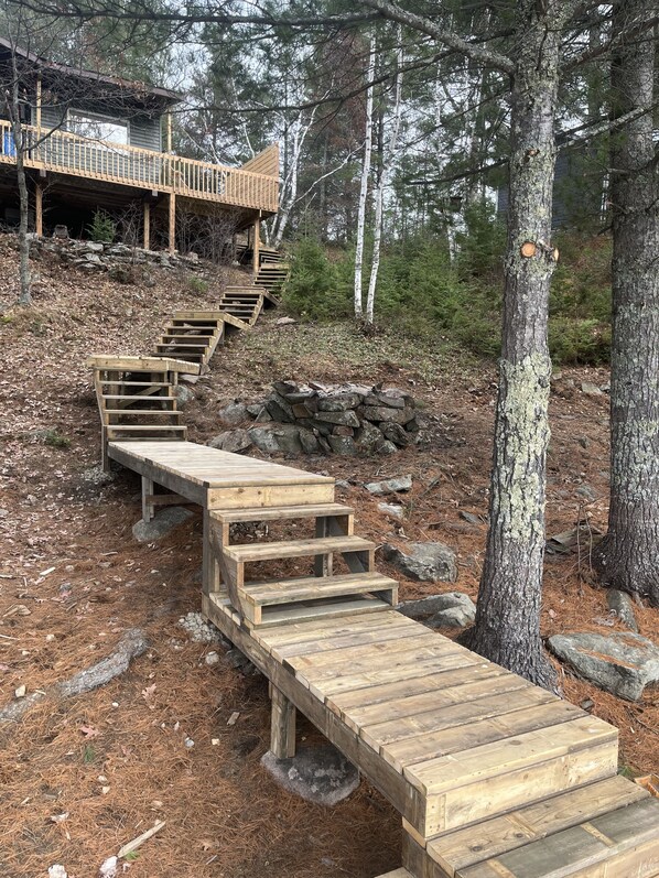 A wooden staircase leading up to a house in a forested area.