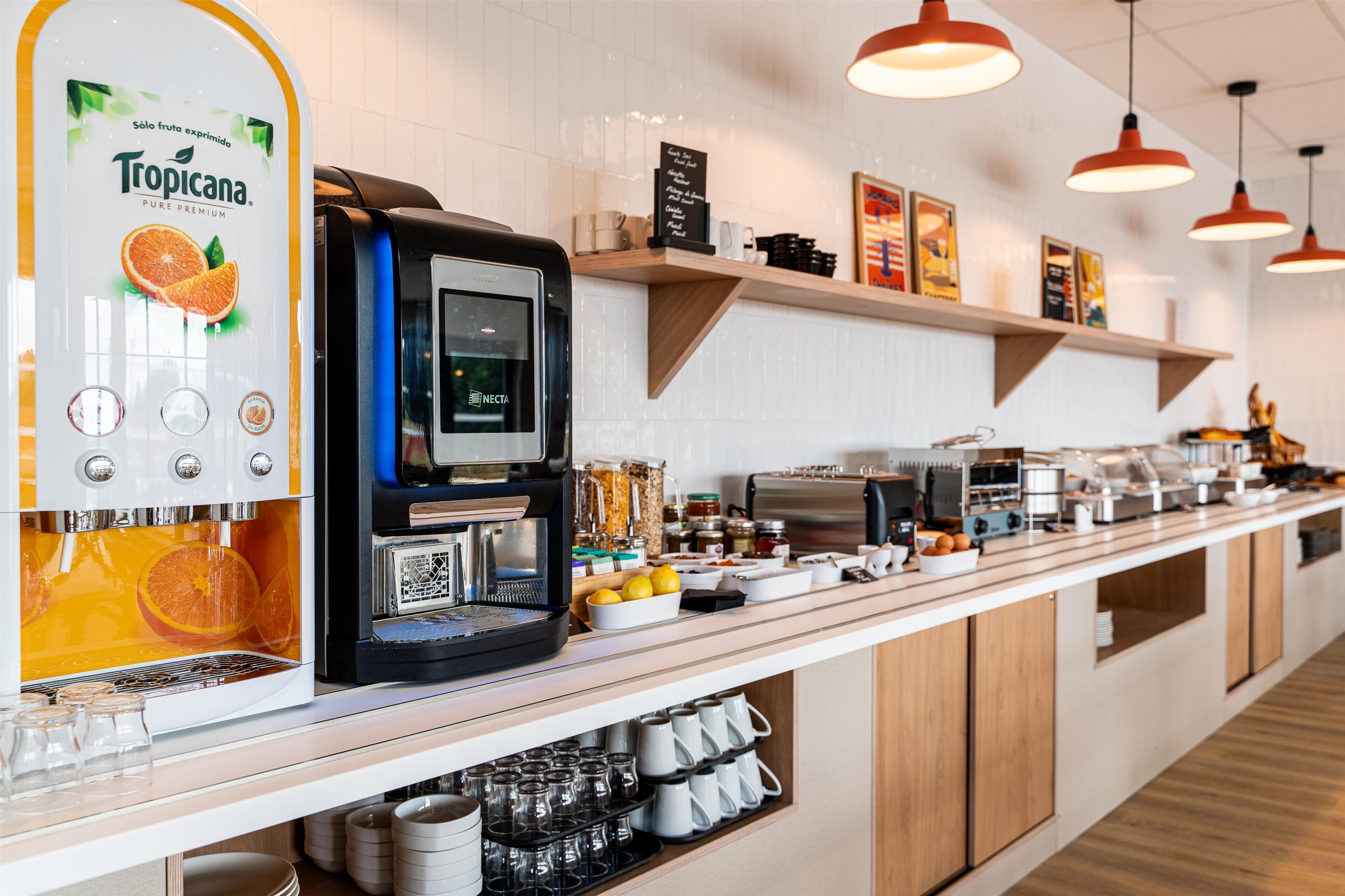 A coffee station with a Tropicana coffee machine, a Necta coffee maker, and various coffee-making equipment.