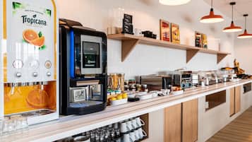 Una zona de cafè amb una màquina de cafè Tropicana, una cafetera Necta i diversos utensilis per preparar cafè.