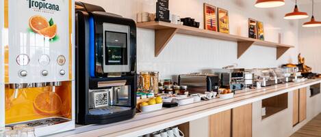 A coffee station with a Tropicana coffee machine, a Necta coffee maker, and various coffee-making equipment.