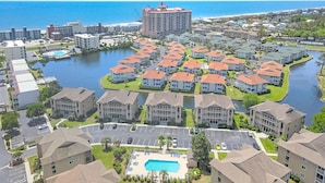 A residential area with a central swimming pool surrounded by houses with red roofs.