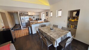 Un espace de vie compact comprenant un coin repas, une cuisine et un petit coin salon.