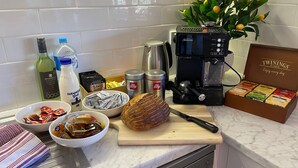Eine Küchenarbeitsplatte mit einer Kaffeemaschine, einem Brotlaib und verschiedenen Lebensmitteln.