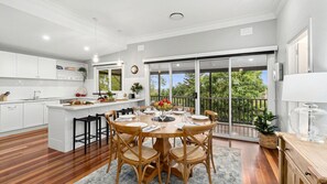 Enjoy meals in the spacious kitchen with a central island, sink, and dining area offering a view of lush greenery from the balcony.