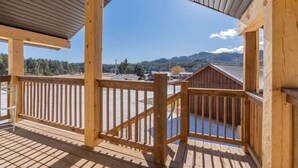 A wooden deck with a railing, overlooking a snowy landscape and buildings. - Custer`s Loft at Gold Valley Camp| 1 Bed, 1 Bath (Custer)