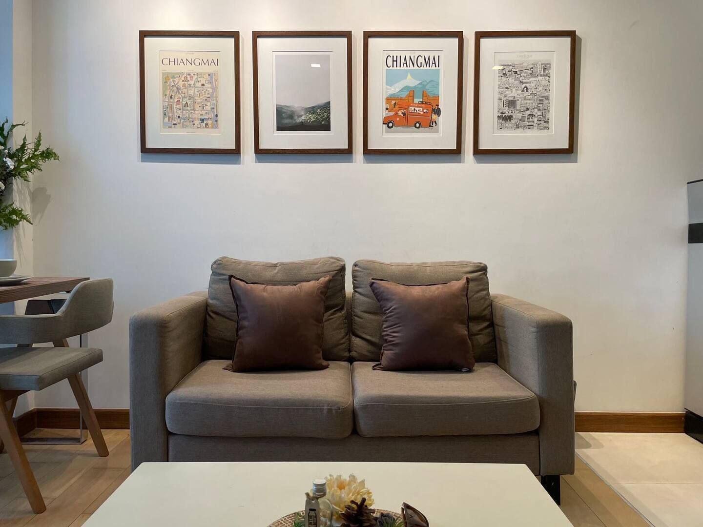 A modern living room with a sofa, a coffee table, and framed artwork on the wall.