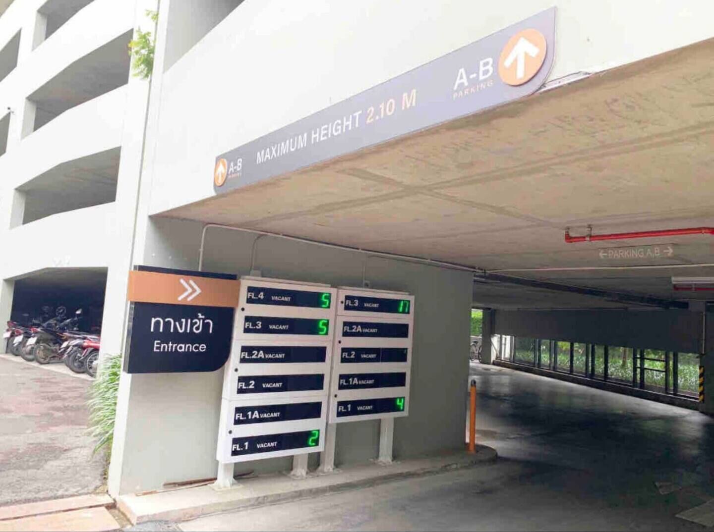A parking garage entrance with multiple levels and a height limit sign.