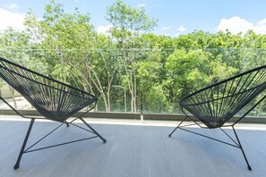 Two black wireframe chairs on a balcony with a view of a dense forest. - Relaxing 1 BDRM, 1 BR, Balcony & Pool Access Apt (Tulum)