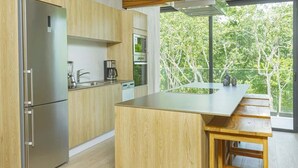 A modern kitchen with wooden cabinets, stainless steel appliances, and a large island. - Relaxing 1 BDRM, 1 BR, Balcony & Pool Access Apt (Tulum)